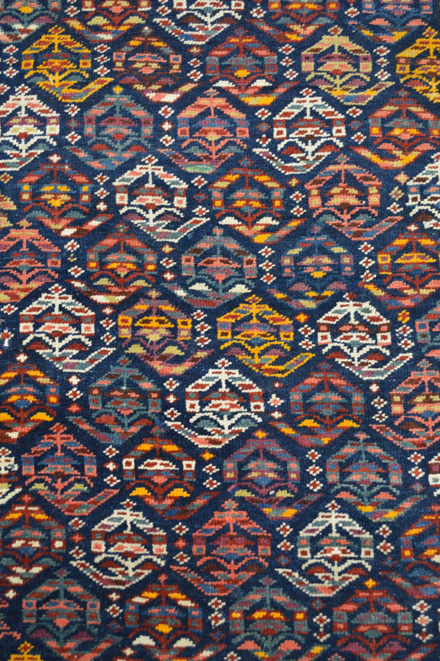 The center of the rug renders blue background with an hexagon pattern on top. These little hexagons are made of small pieces.