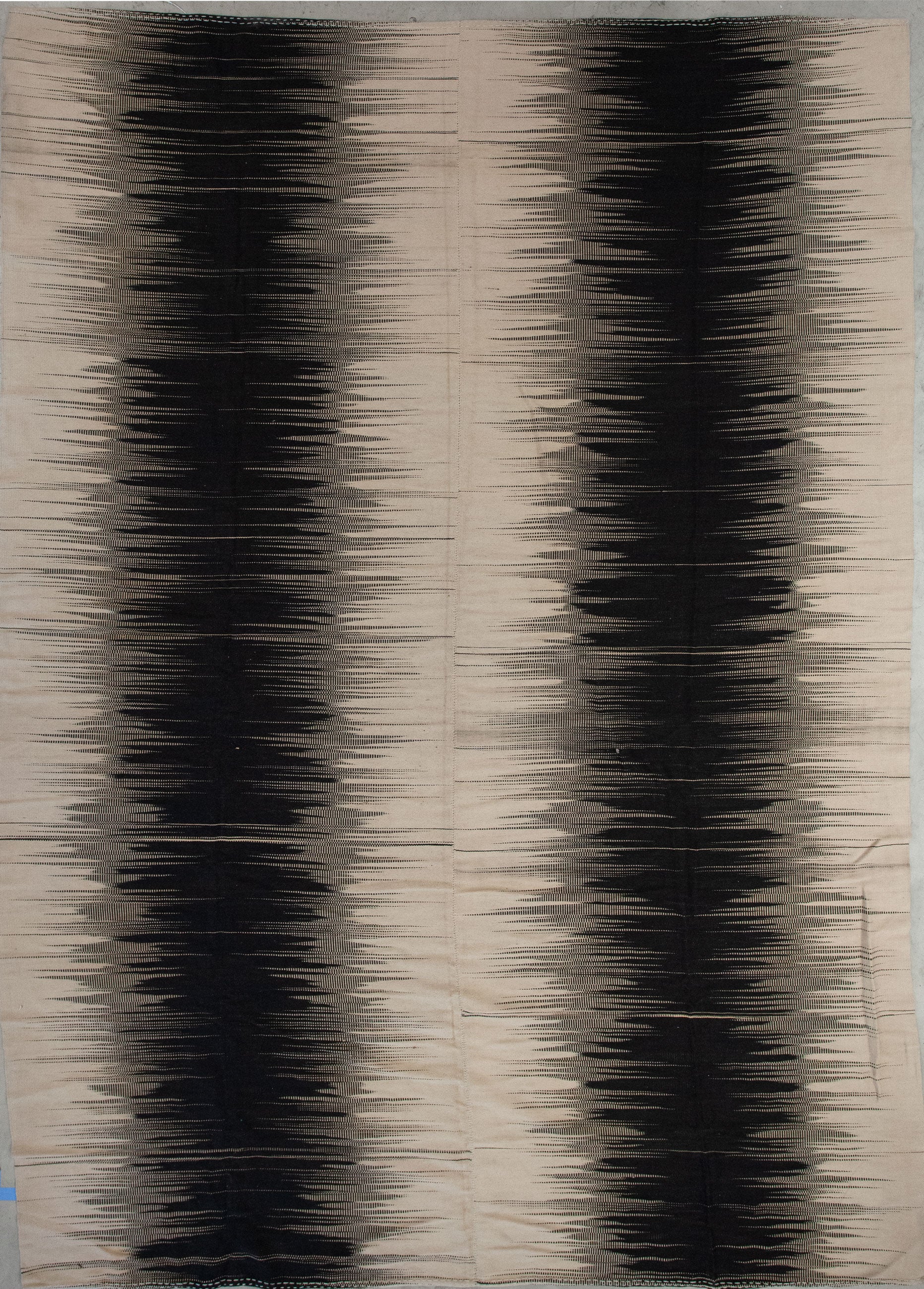 Excellent rug has beige background with an interesting pattern in black.