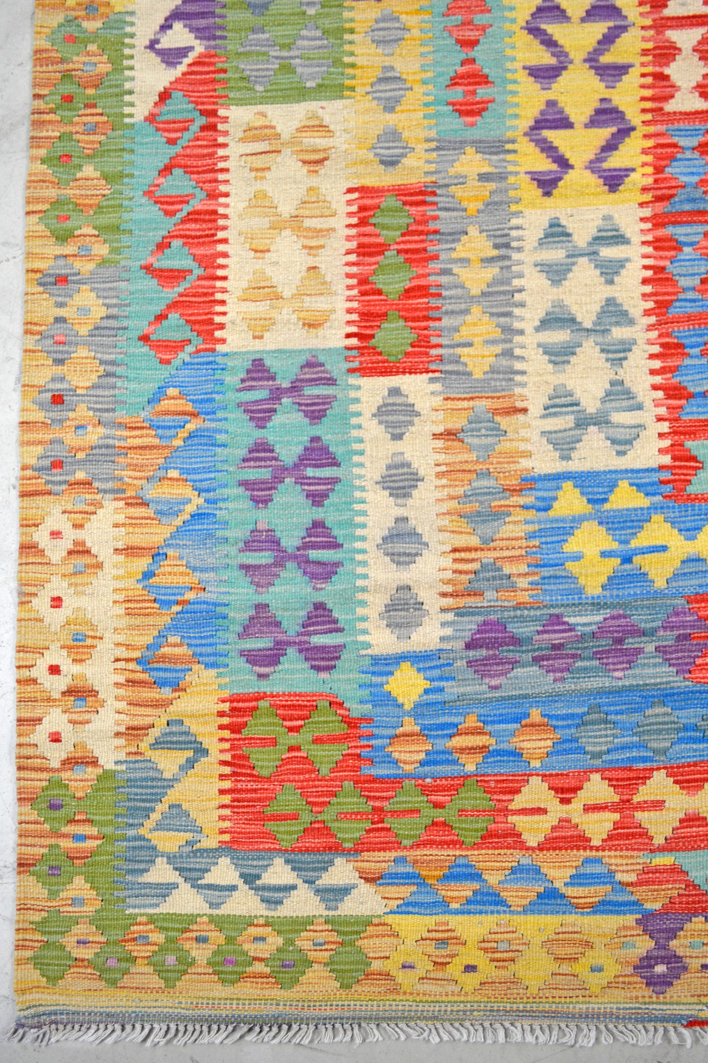 On the bottom left corner, there are seven thin borders knitted in different colors with abstract rhombuses.