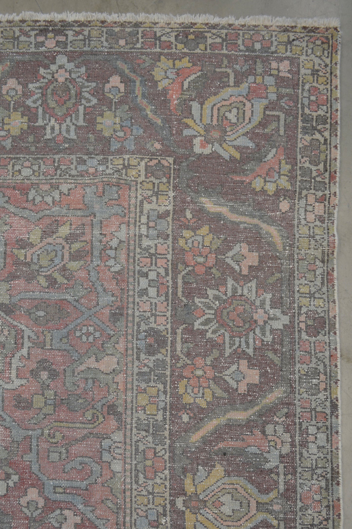 On the top right corner, there is a thicker frame with beetles, leaves, and flowers knitted in light blue, yellow, and salmon.