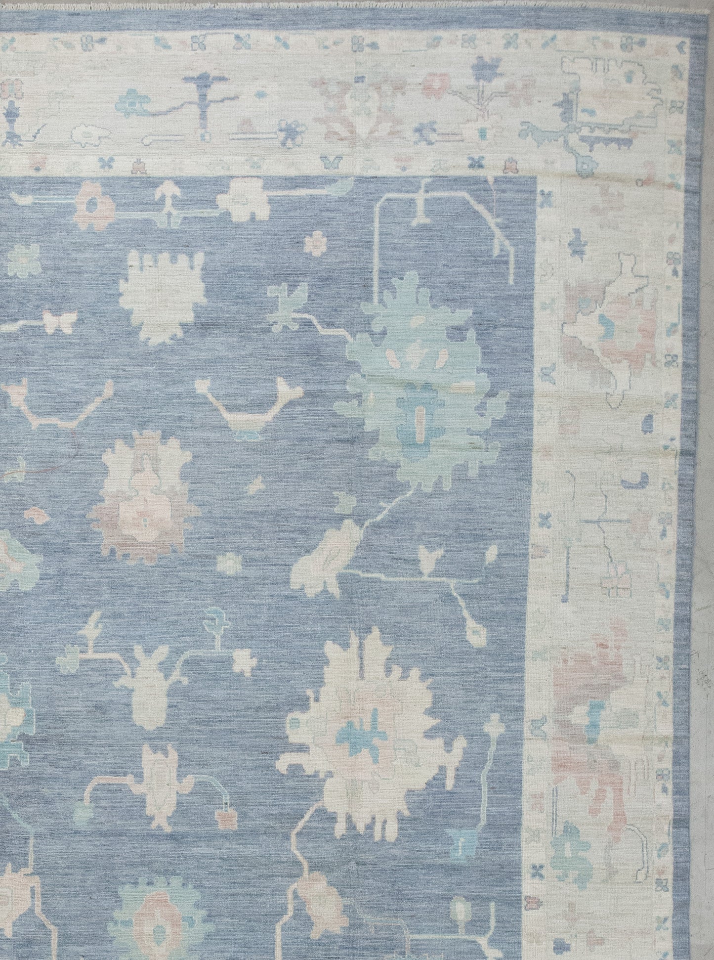 The beige borders have small butterflies and flowers, while the beige thick frame has abstract corals knitted with blue and brown accents.