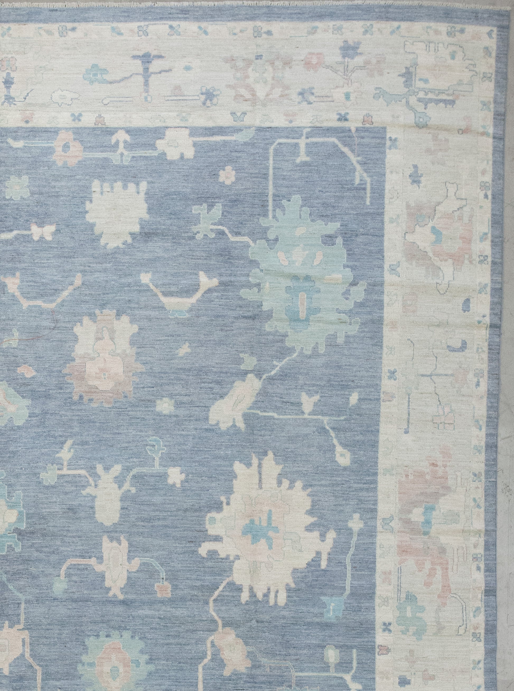 The beige borders have small butterflies and flowers, while the beige thick frame has abstract corals knitted with blue and brown accents.