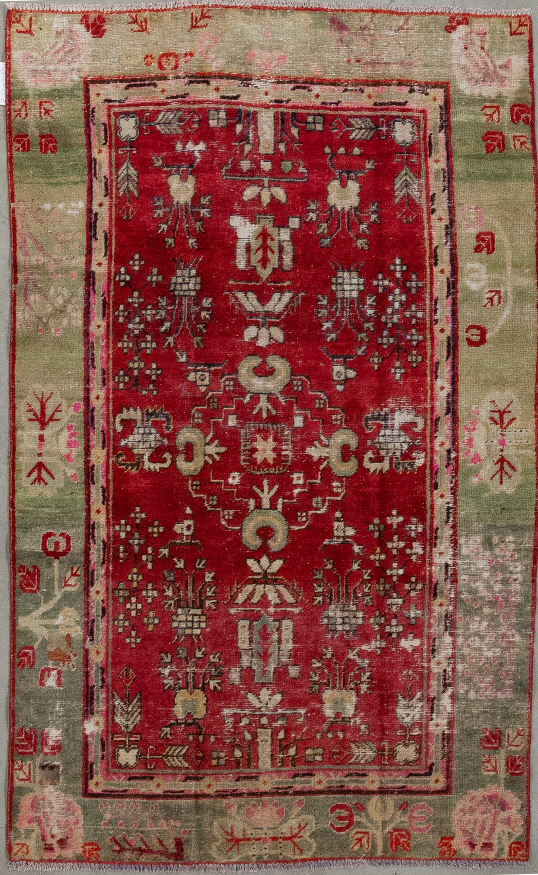 This passionate carpet was woven with ruby red for the background in the center, while the contour has yellow-greenish tones depending on the lightning in the room is the perception of the colors. The design features abstract curved croissants and crabs.