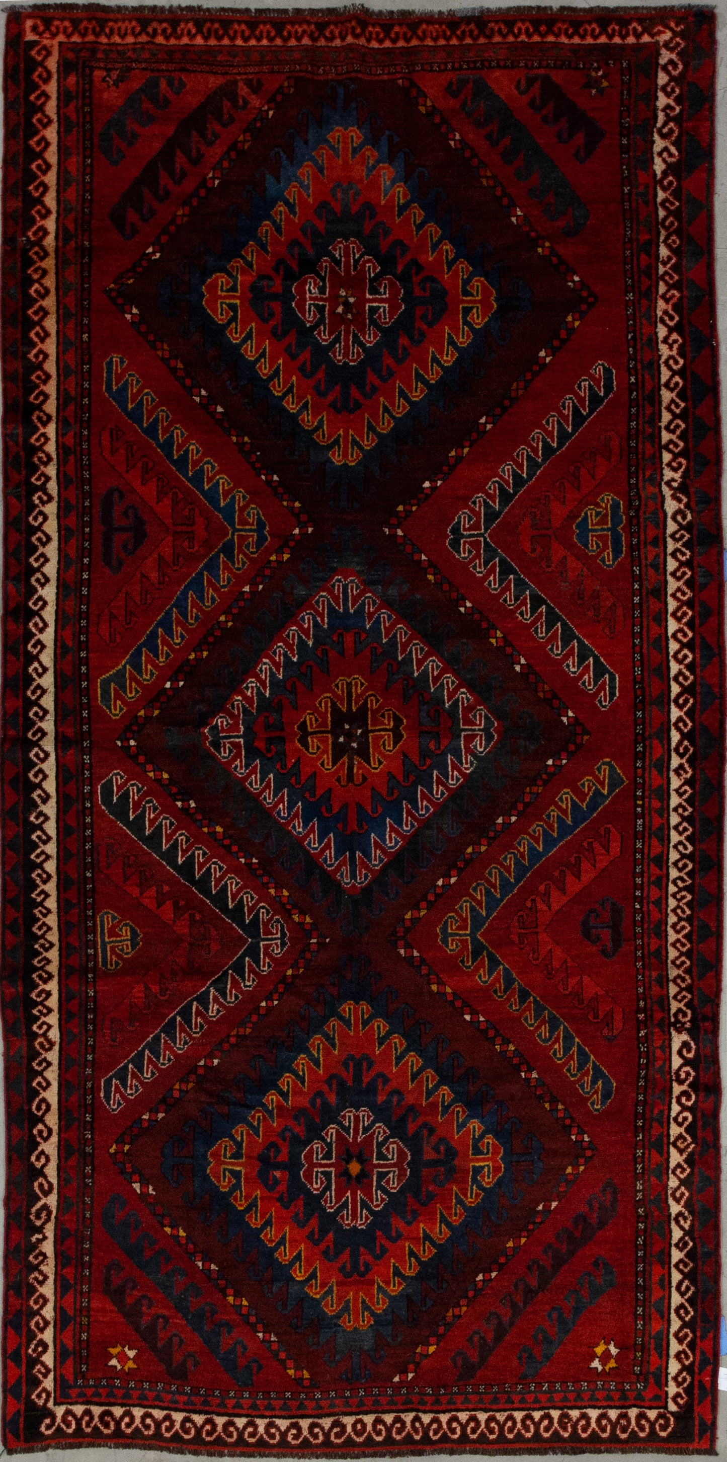 This powerful carpet comes with an intense and vibrating color scheme which has variations of red as the dominant tone plus orange, blue, yellow, brown, and white.