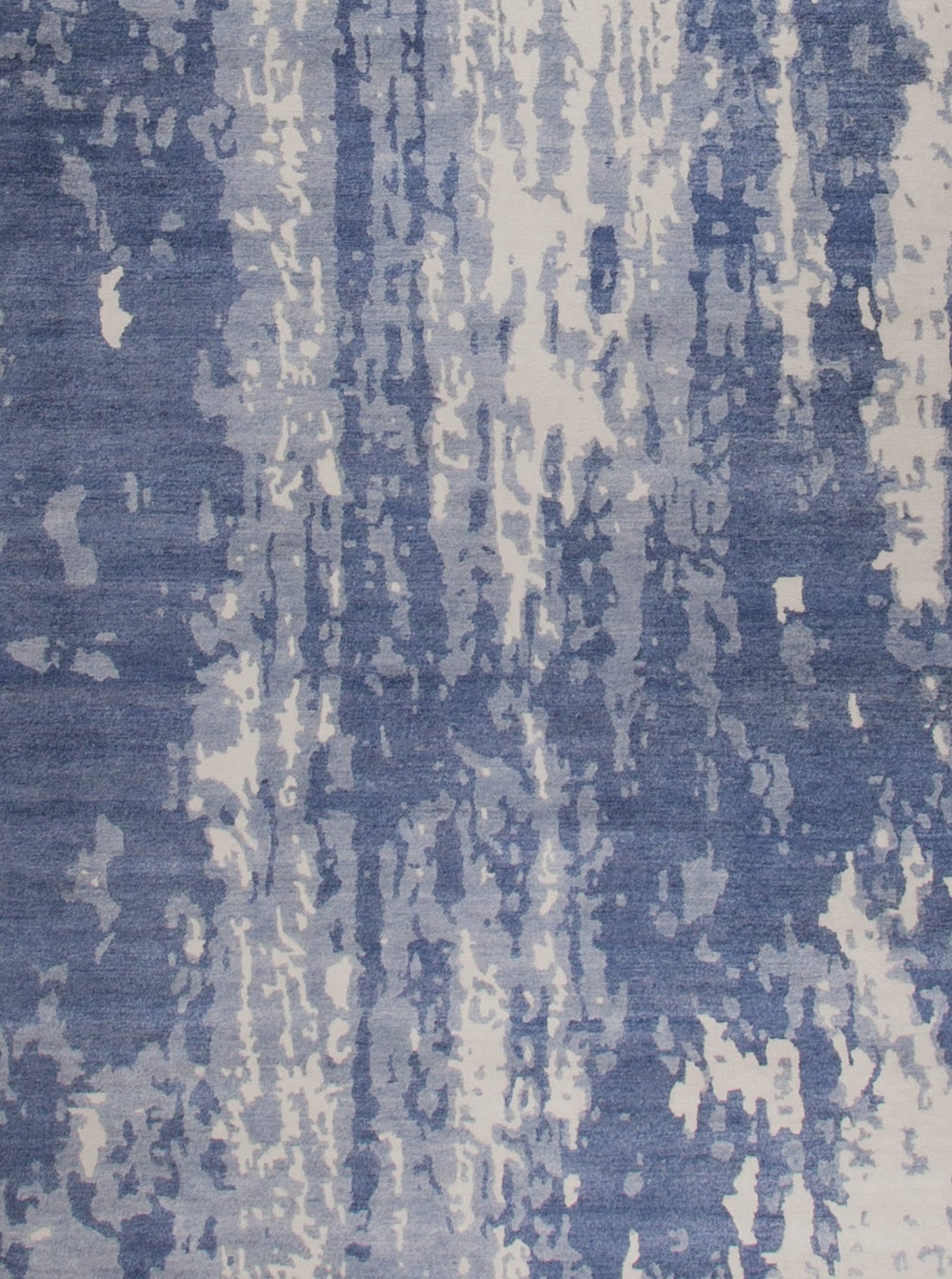 the close up of the center of this rug shows white, light blue, and navy blue.