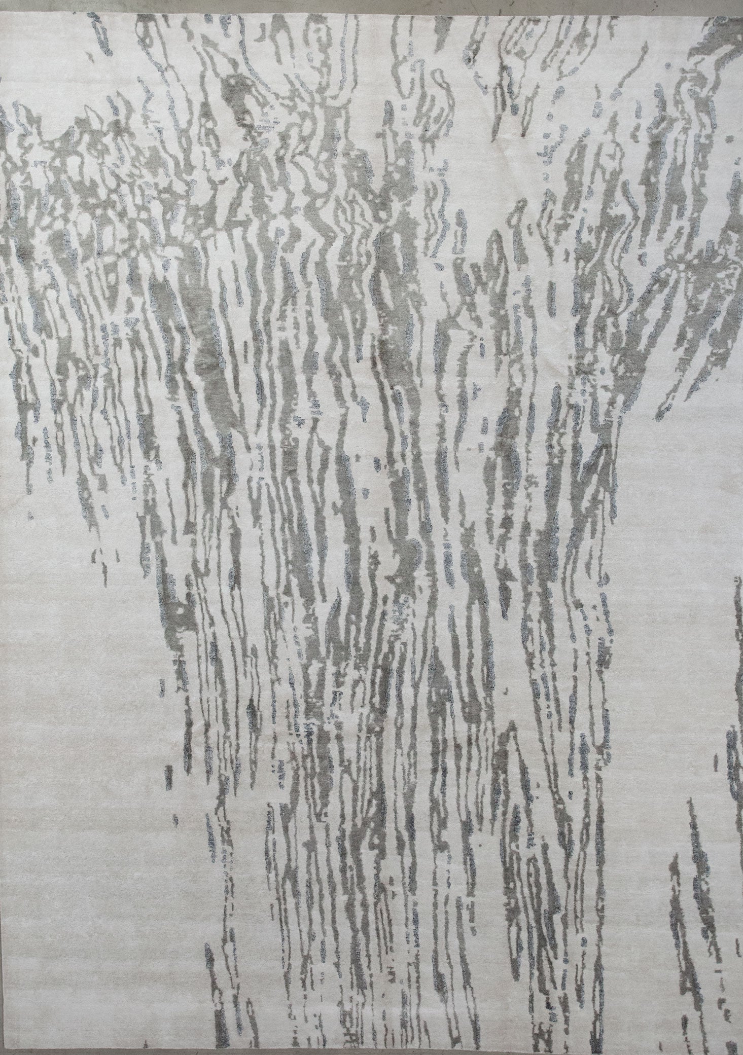 Elegant rug comes with white background and a gray water fall design on top.