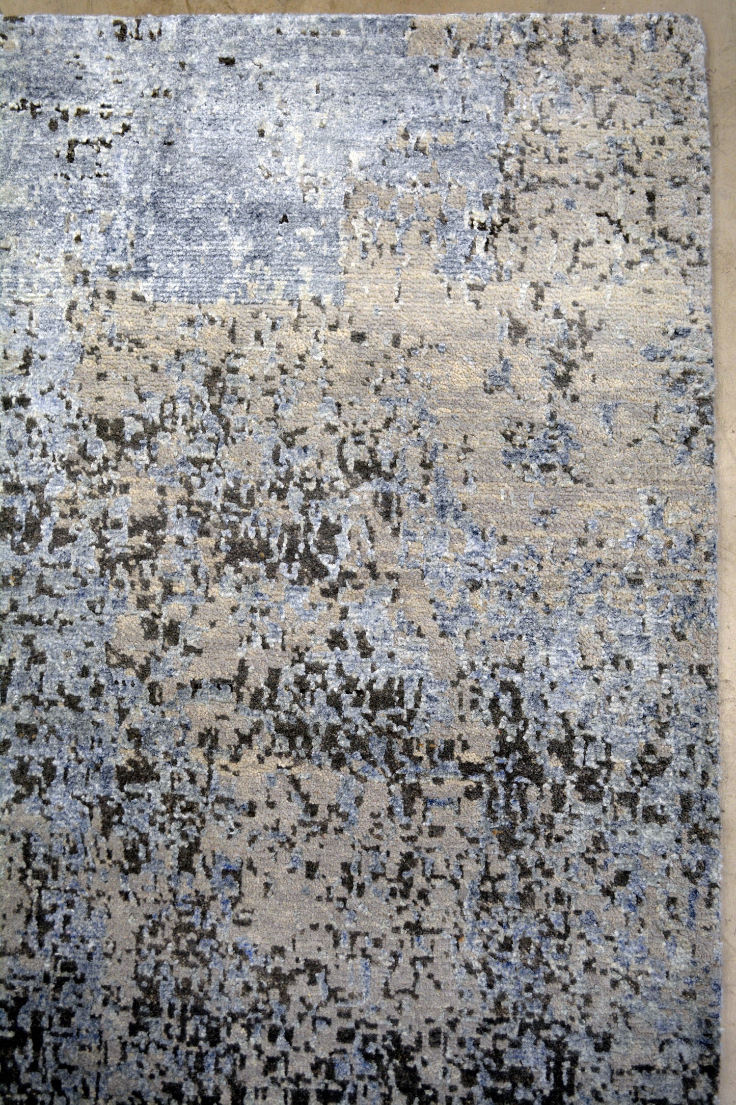 On the top right corner, the light tones of the rug grab more attention.