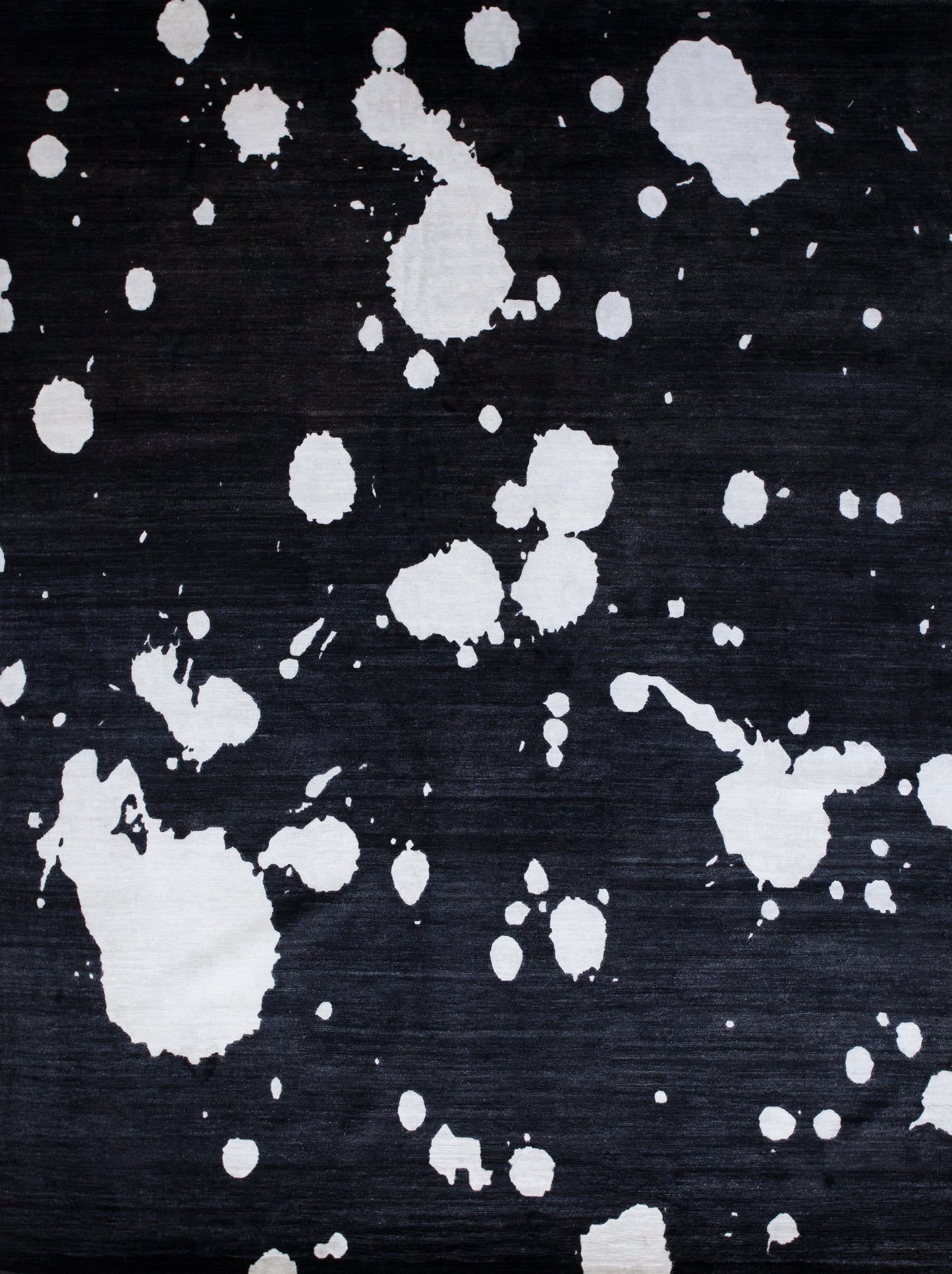 Black modern rug has white splashes design on top. This stylish rug matches with any room in your home.