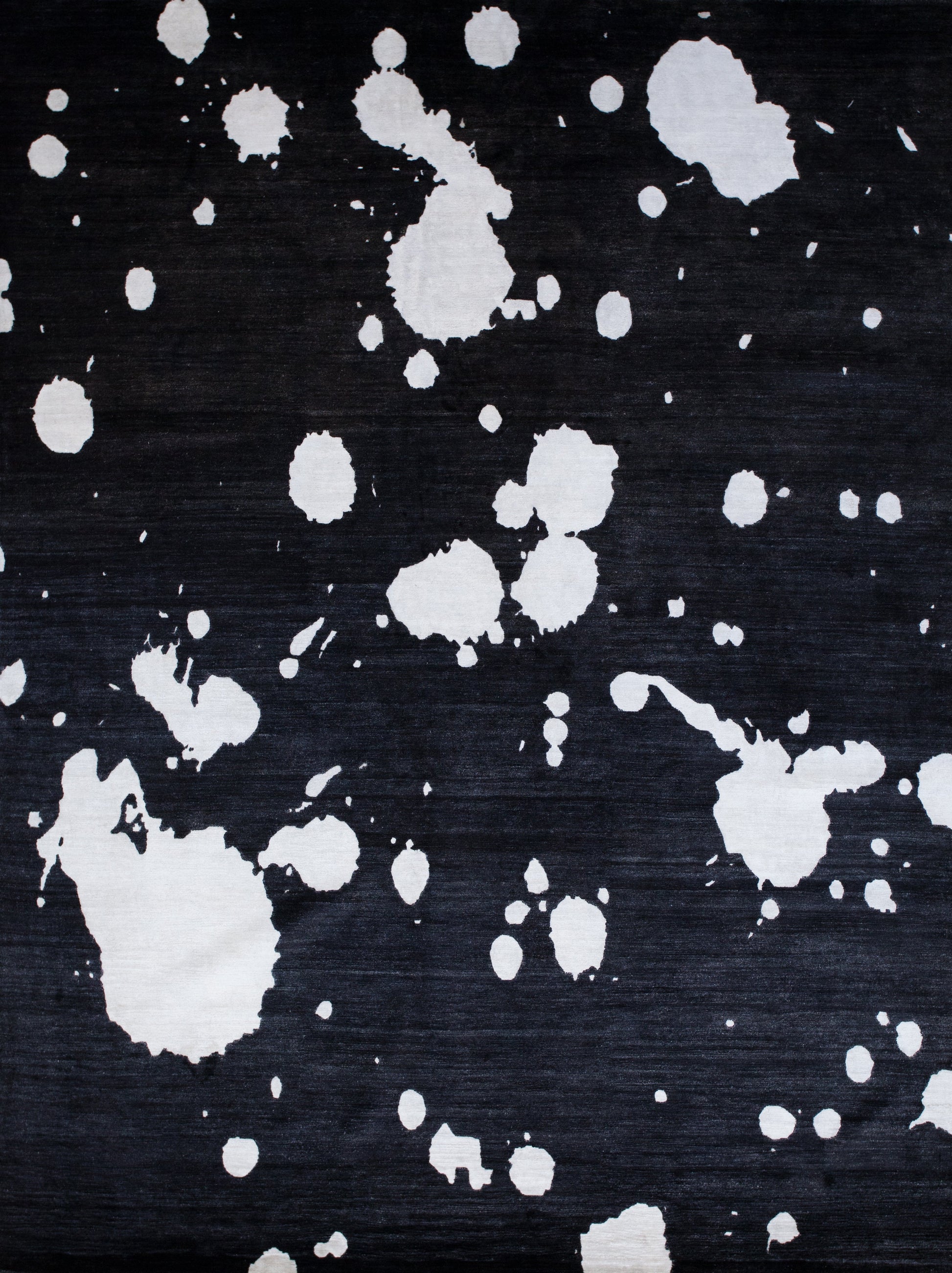 Black modern rug has white splashes design on top. This stylish rug matches with any room in your home.