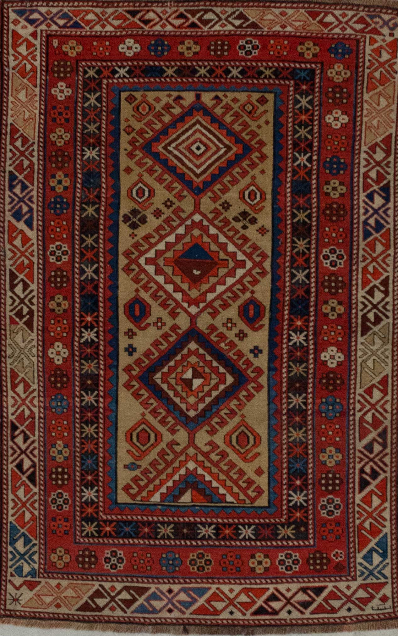 Ancient rug is knotted with orange, red, white, blue, red, beige, and yellow.