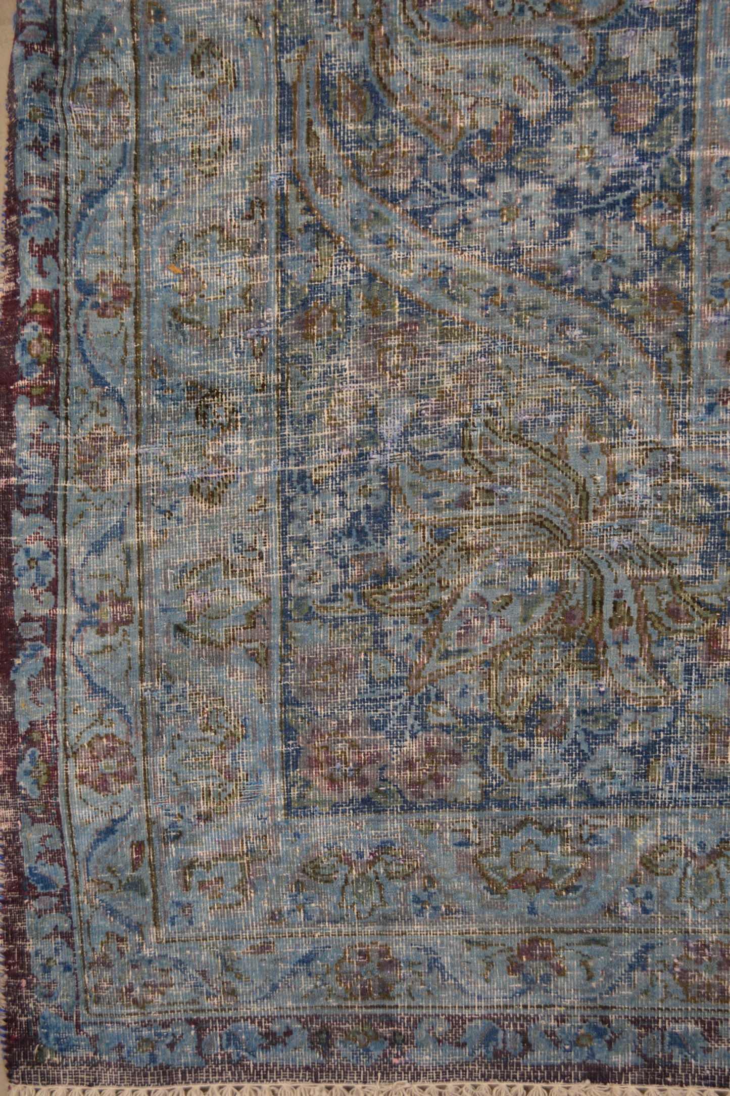 on the bottom left corner the distressed finish covers all the frames and its spread out over the whole rug.