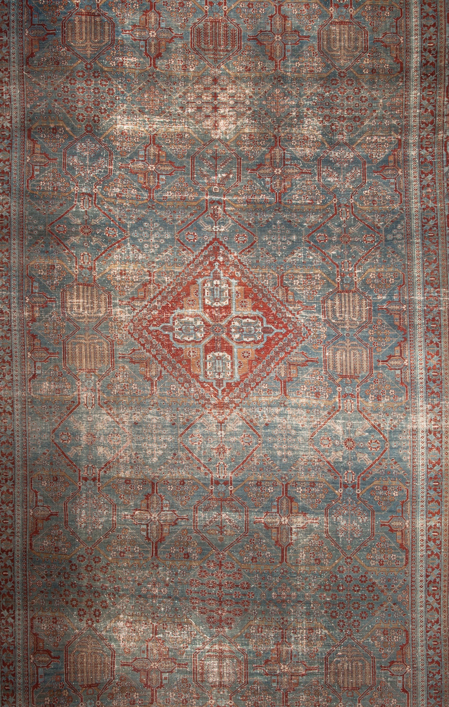 The center focal area of the rug has a red rhombus with a geometrical pattern.