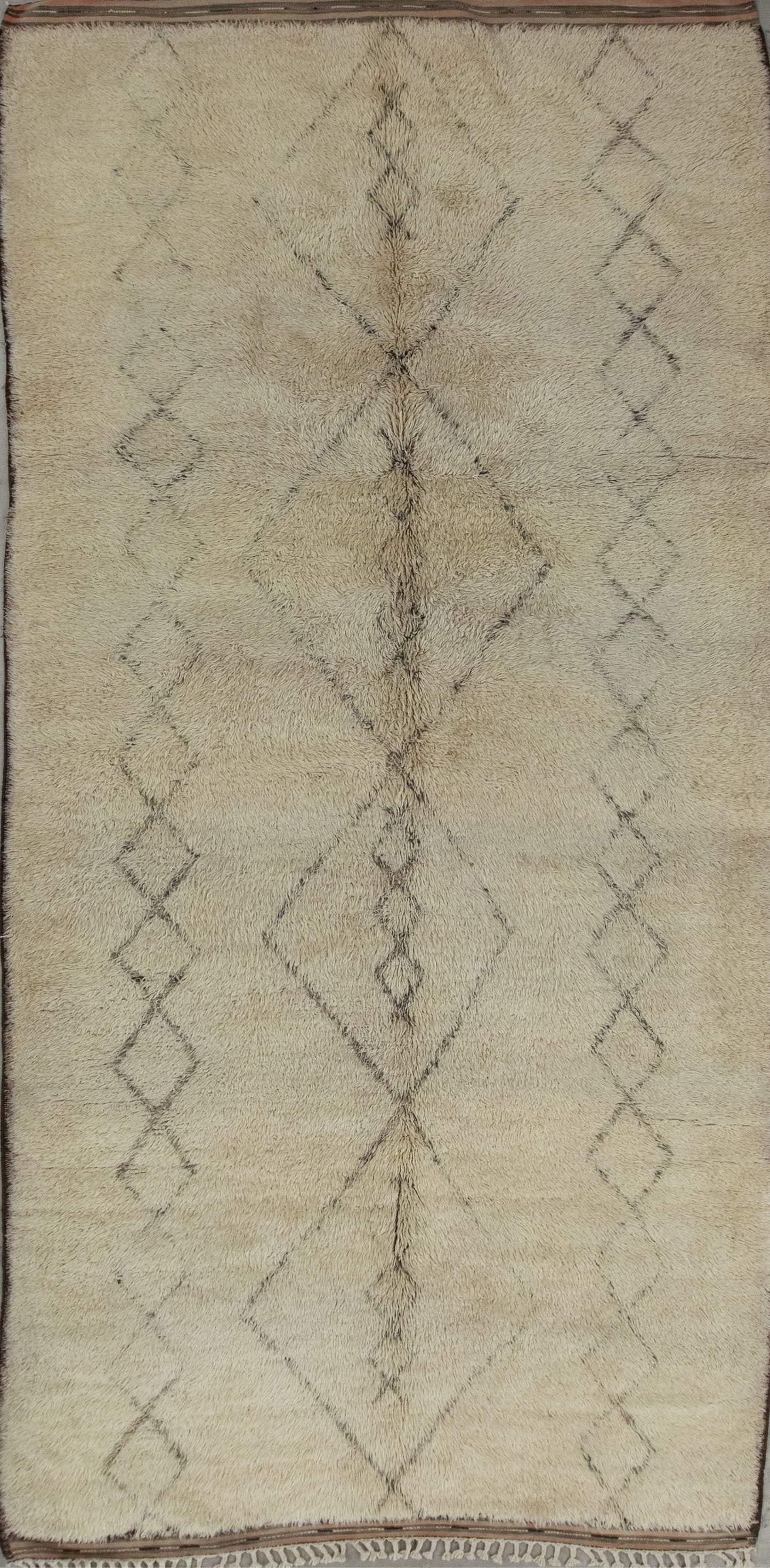 Off-white rug with two thin columns of rhombuses placed each one on each side of the main four central diamonds composition.