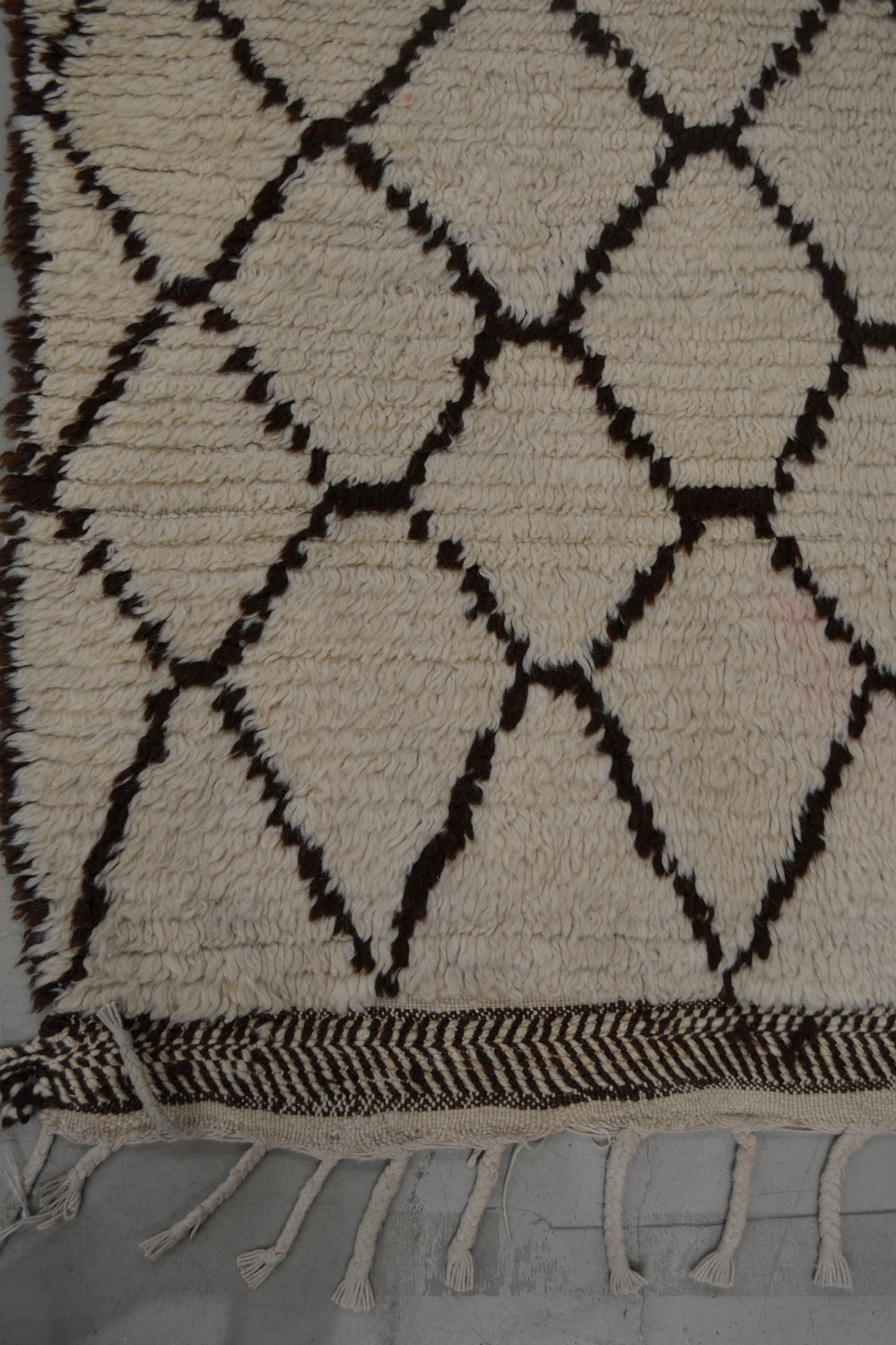 on the bottom there are fringes and a thin border with a diagonal lines pattern.