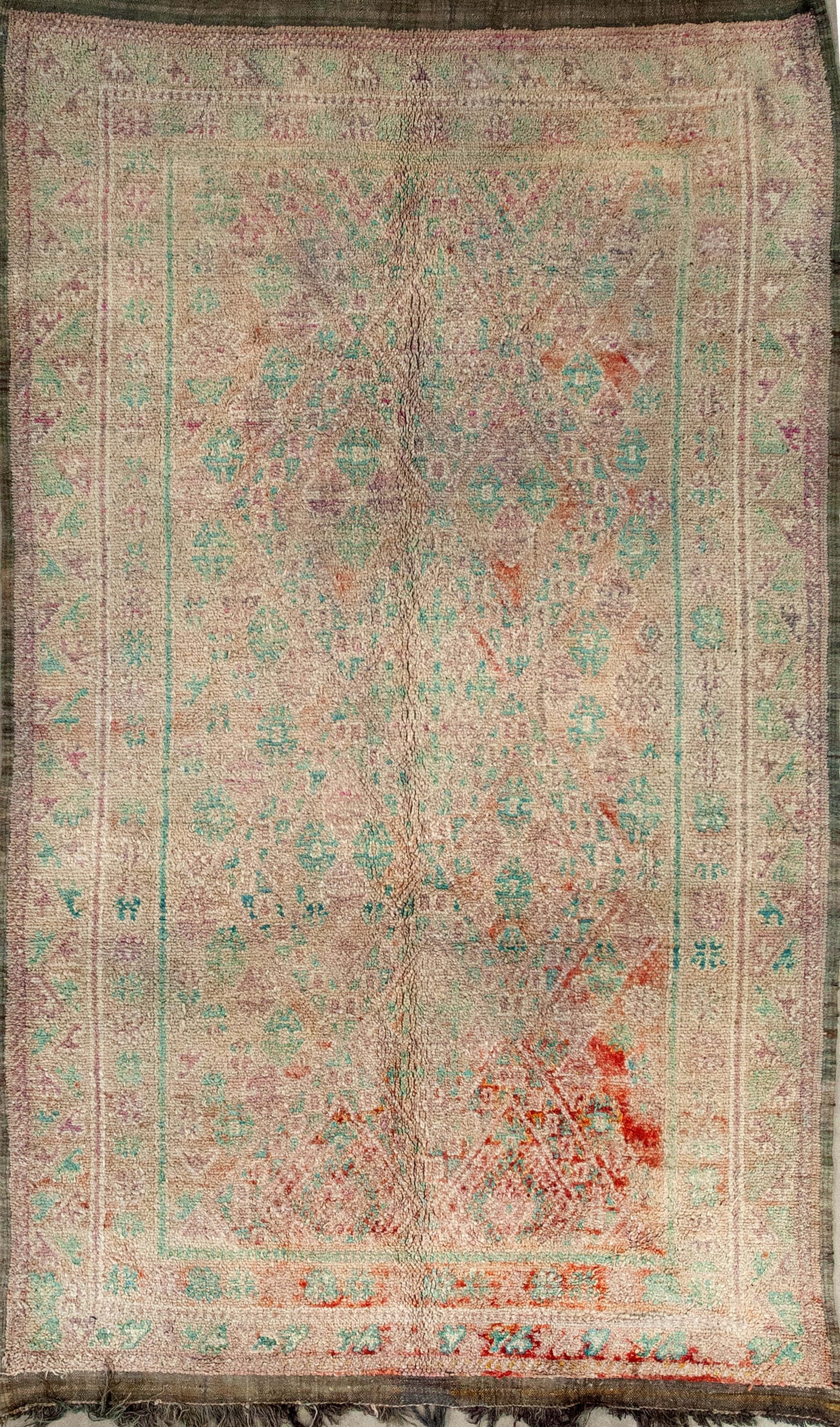 This vintage rug comes with a diamond design pattern in light green and pink.