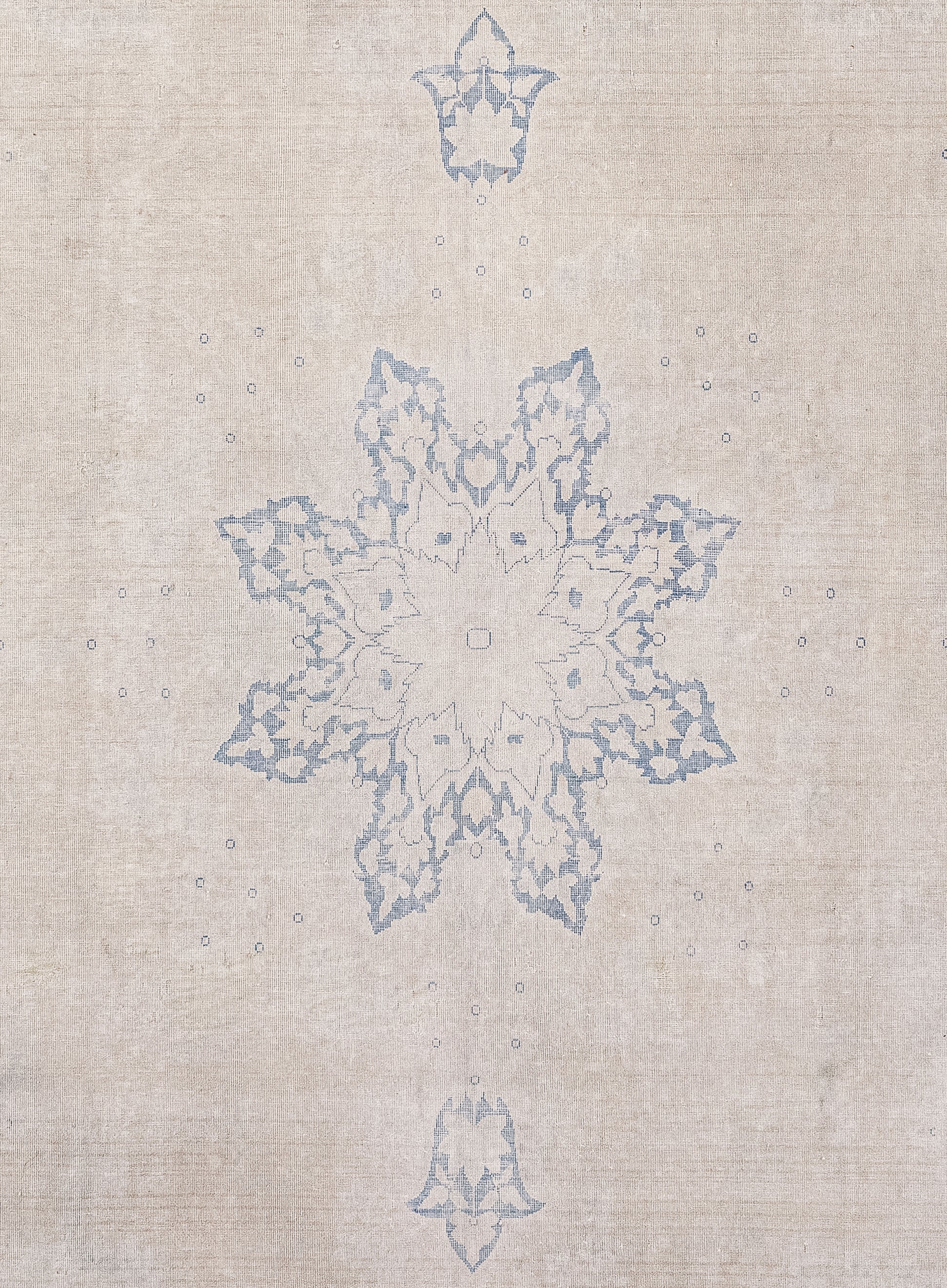The rug's close-up features a large snowflake in the center with two heraldic fleurs-de-lis at the top and bottom in blue.