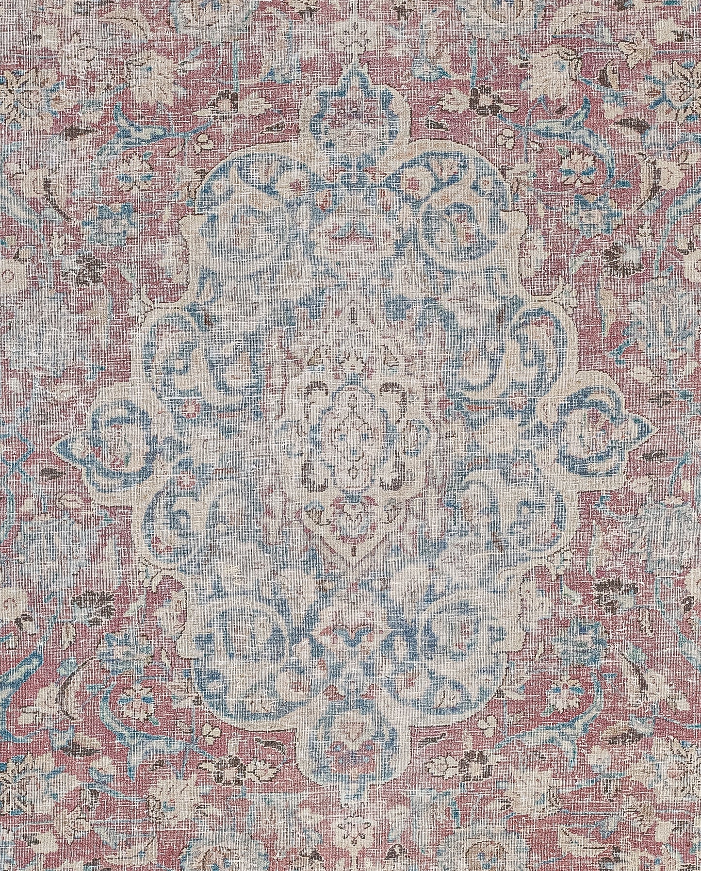 The entire rug comes with a symmetrical flower motifs pattern. The close-up of the rug shows a beige ornament filled with blue on a burgundy background.
