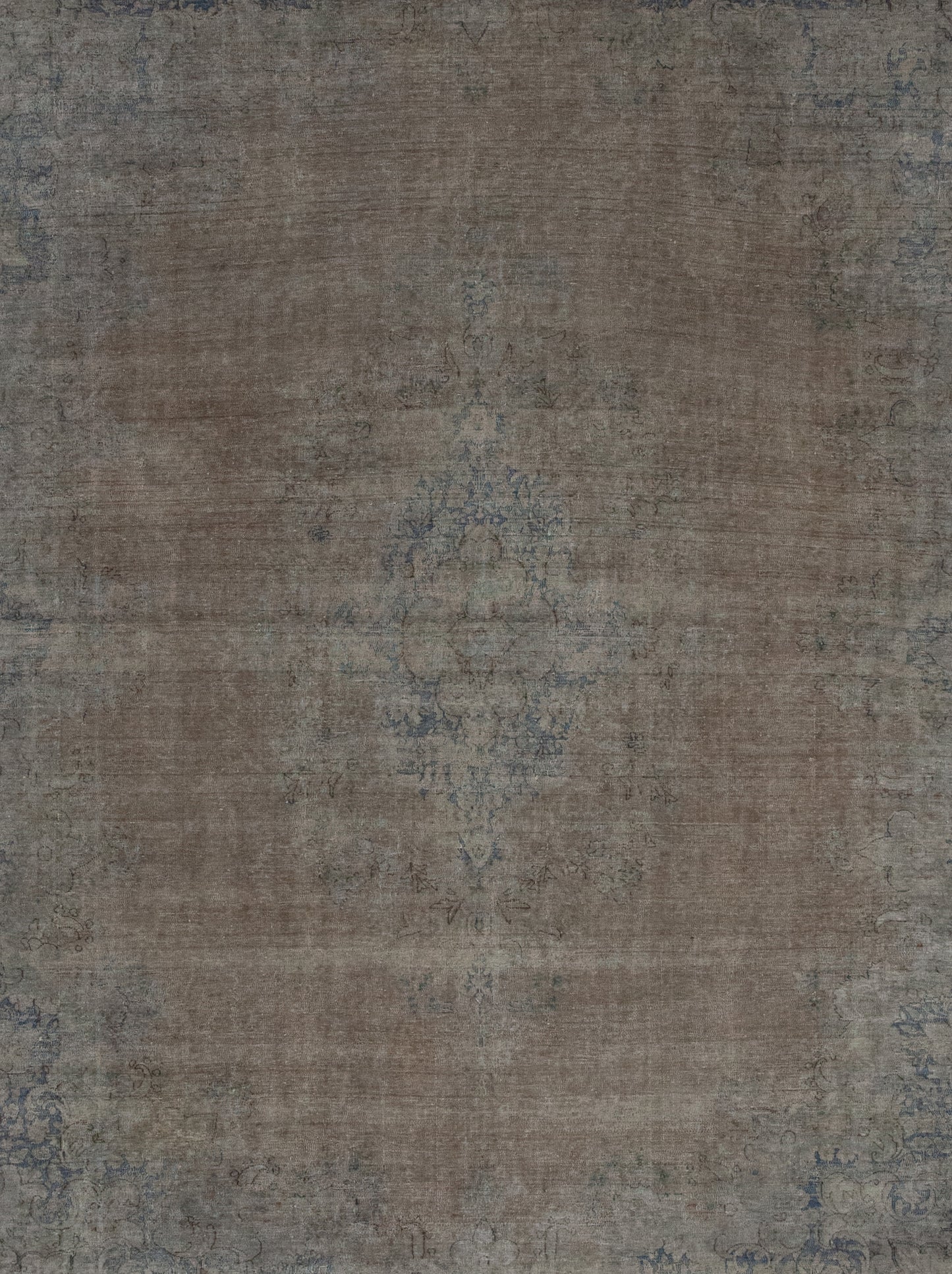 The center of this rug shows a distressed copper color enclosing a small flower in the center.