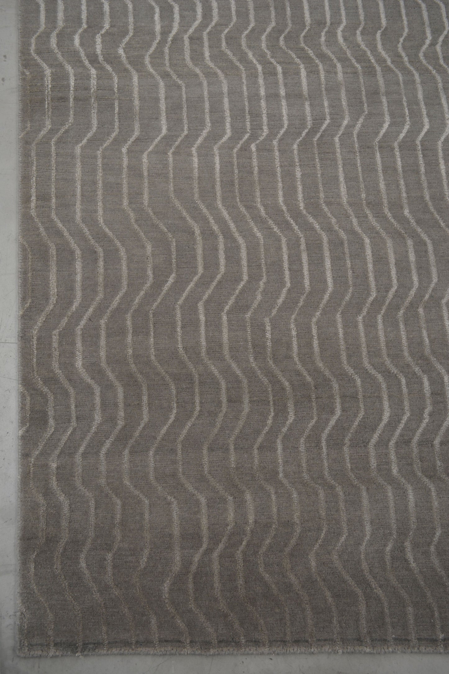 From the bottom left corner, the wave pattern takes over the whole rug symmetrically.