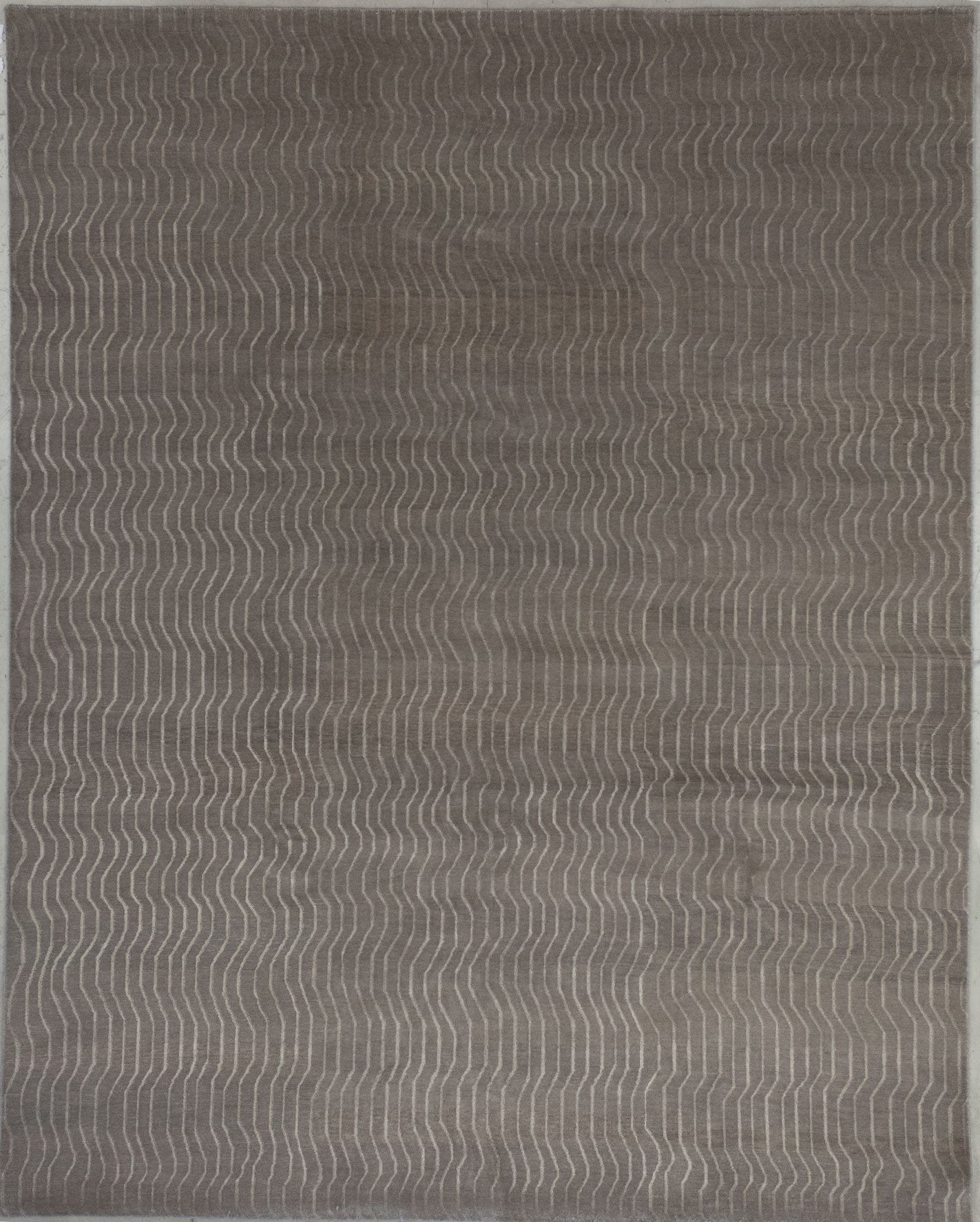Elegant rug comes in monochromatic gray; the background has a dark tone while the pattern renders lighter vertical wave lines