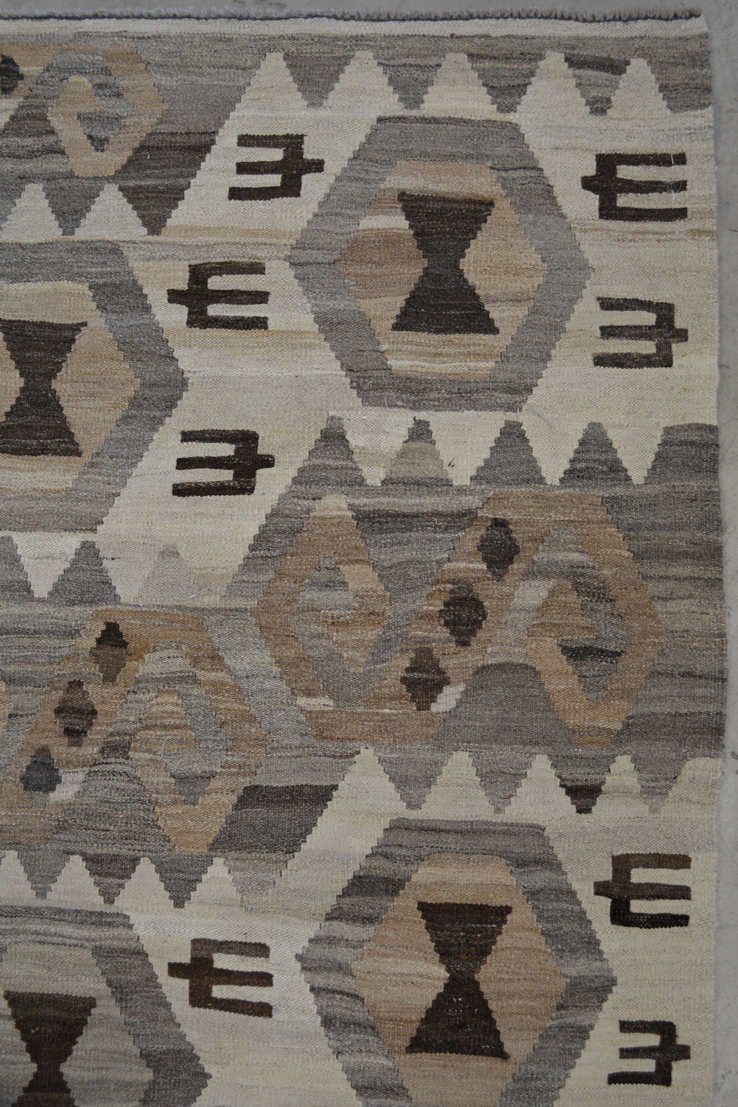  the rug's pattern displays abstract letters "S" that are laid down and they contain three rhombuses each one.