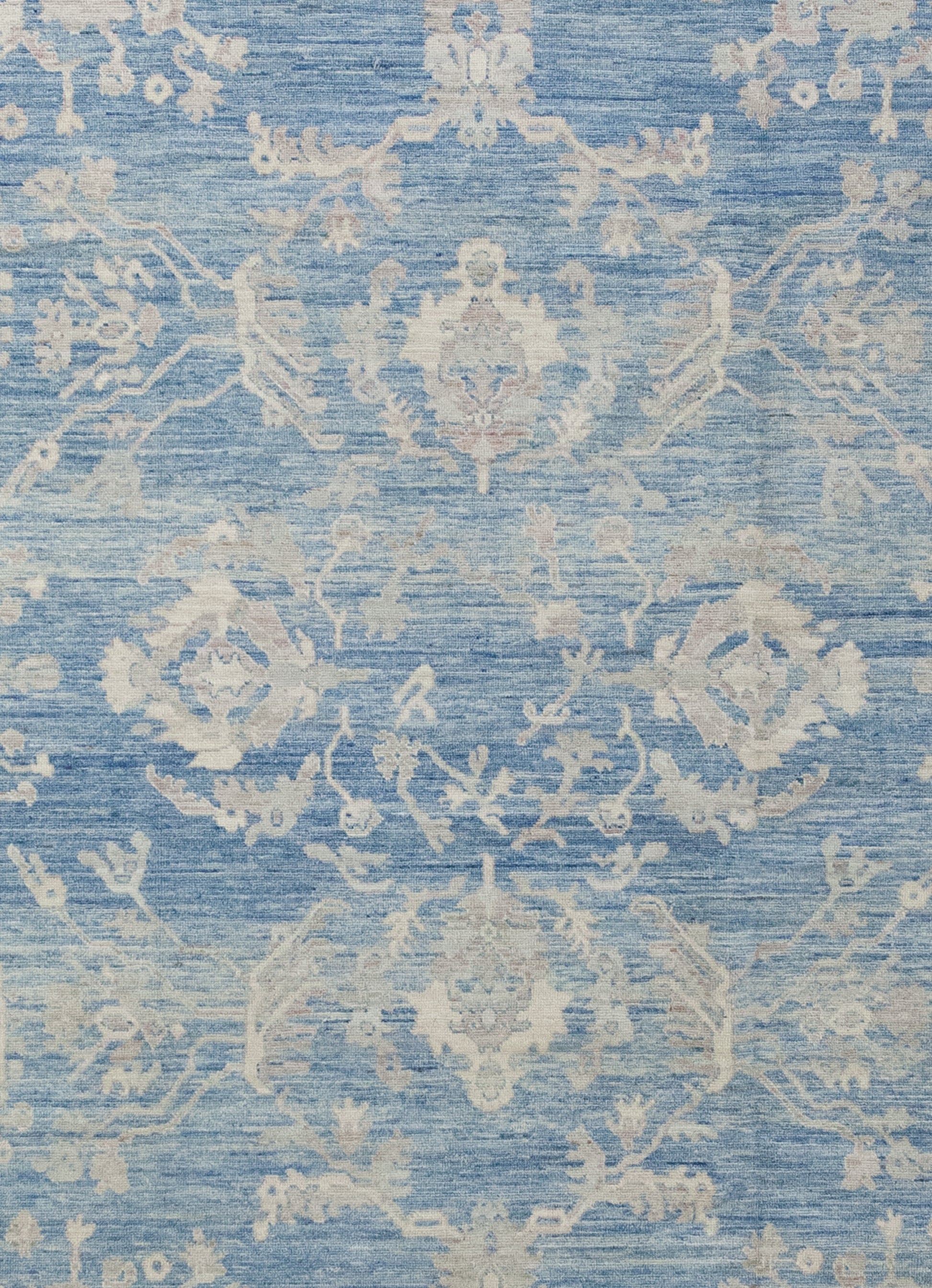 The center of the rug features a large beige ornament to create contrast against the blue background.