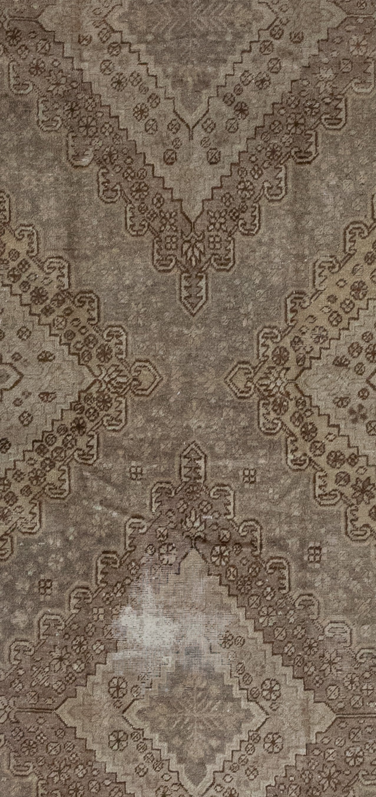 The close-up of the rug displays a large "X" which is formed by the unified two large rhombuses' shapes. 