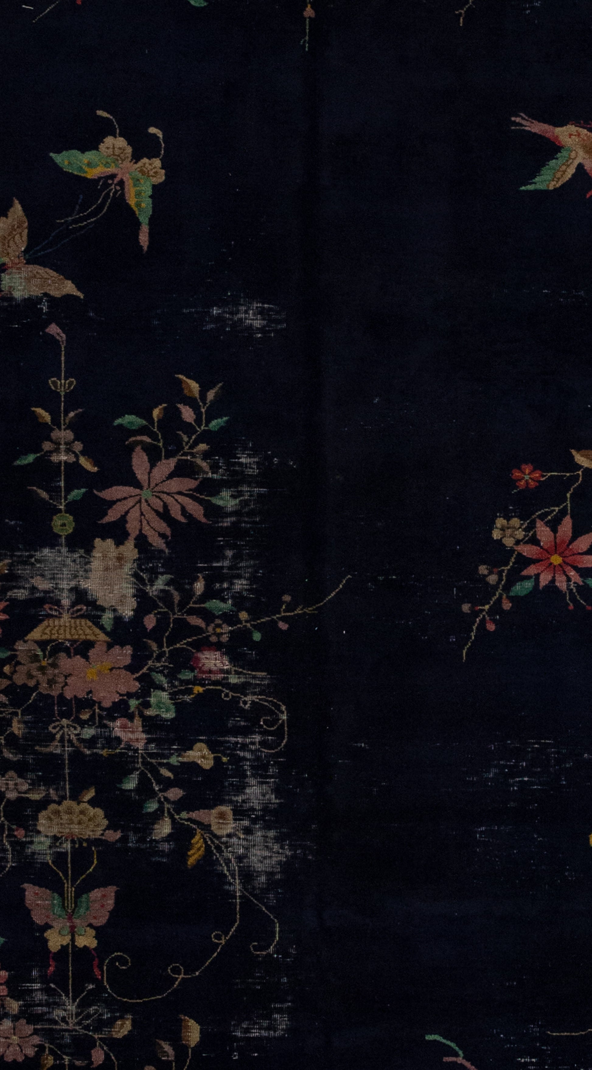 The rug's close-up shows the black background with butterflies, birds and plants distributed chaotically. 