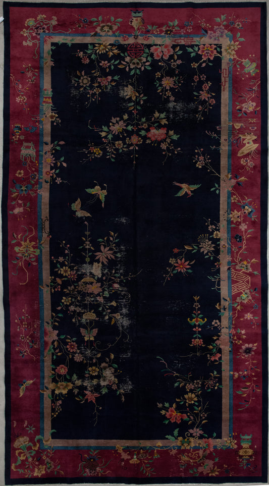 This woven carpet has an explicit and fascinating artwork that expresses nature in its knots. The elegant color scheme has black background, burgundy contour as the secondary tone, and many details in blue, green, yellow, pink, and beige. The asymmetrical artwork features hanging flower pots, golden asters flowers, climbing plants with green leaves, butterflies, and birds. 